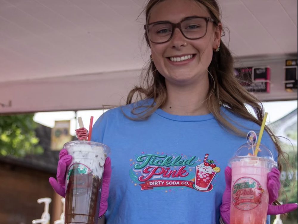 Tickled Pink team member holding two drinks